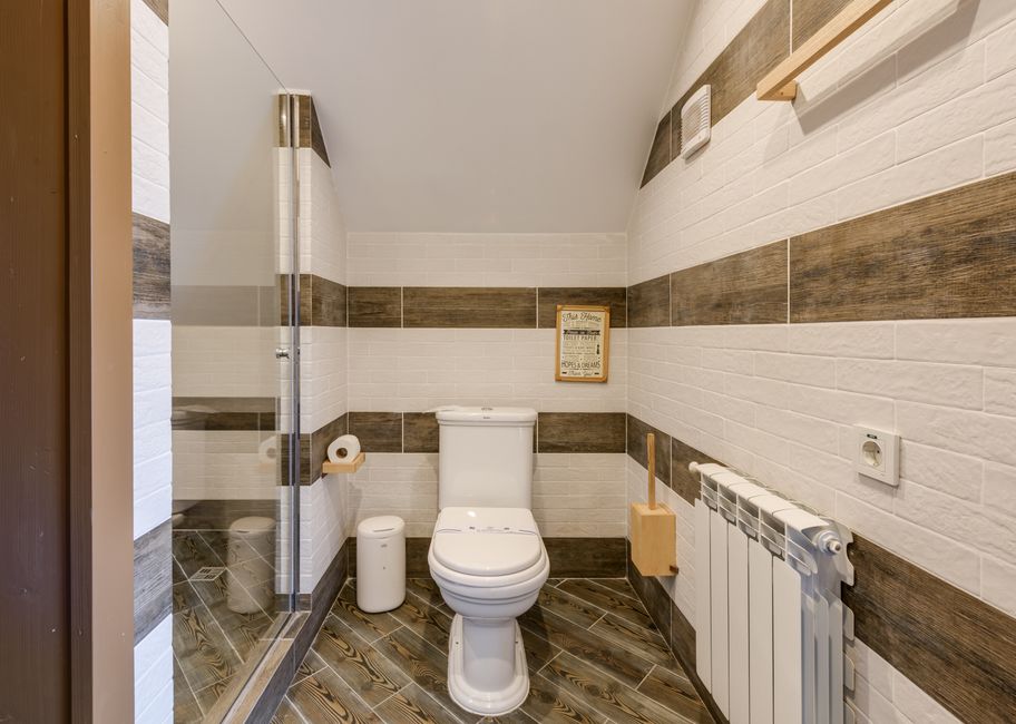 Modern two-piece toilet installed in a clean bathroom - cost of toilet replacement Modern two-piece toilet installed in a clean bathroom - cost of toilet replacement