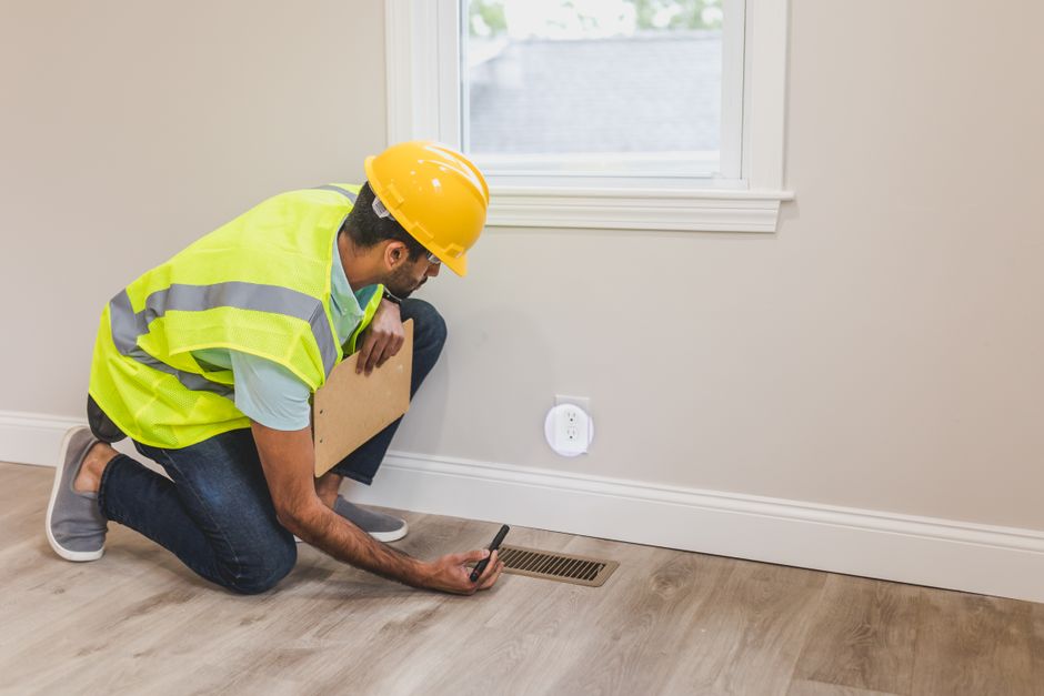 A plumber inspecting a bathroom floor for water damage - cost of toilet replacement A plumber inspecting a bathroom floor for water damage - cost of toilet replacement